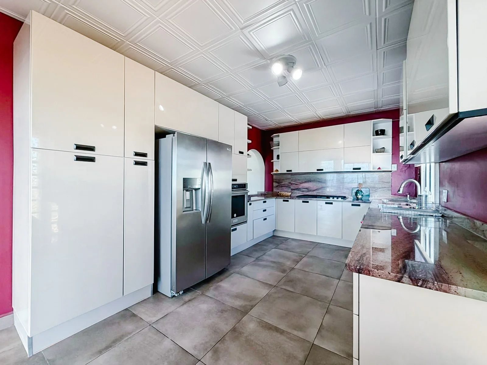 U-shaped kitchen showing the full storage wall, fridge, double oven and gas cooktop