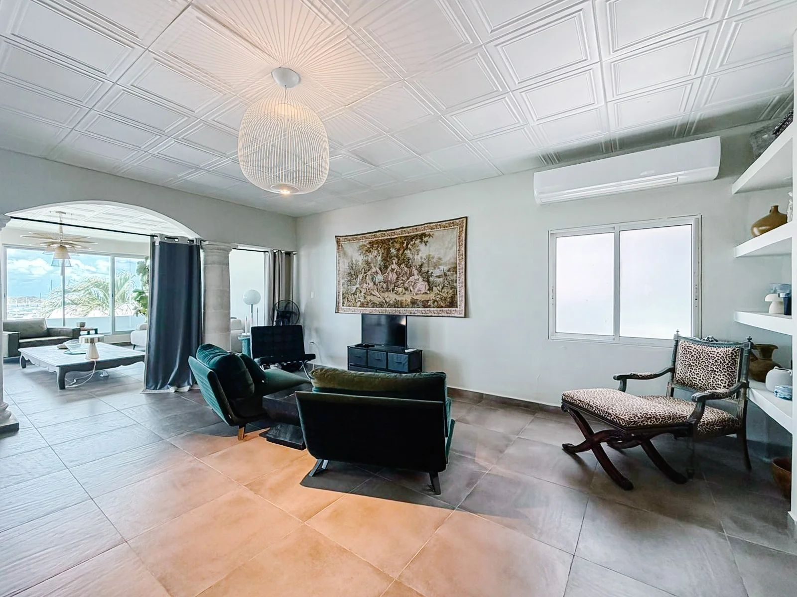 Second living area with TV, emerald velvet chairs, antique tapestry and leopard chaise