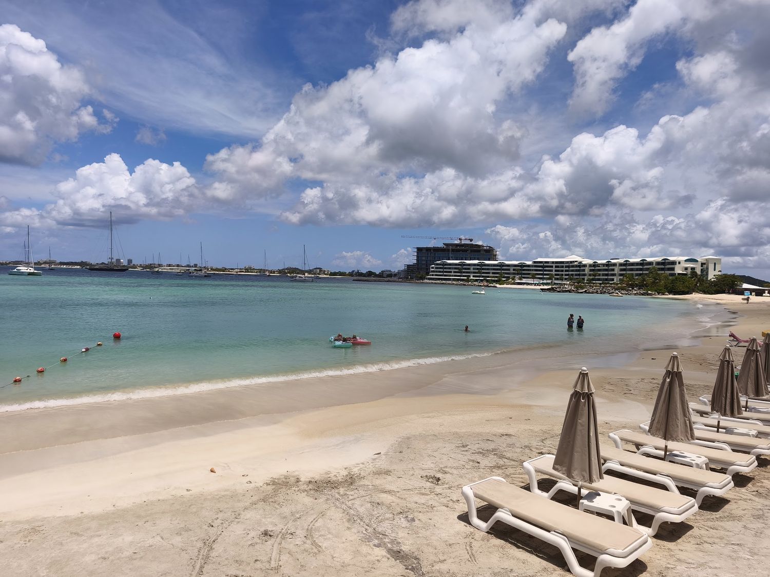 Pelican Bay beach with loungers, calm turquoise water and resort across the bay